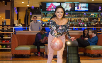 girl bowling with a dark pink bowling ball during the sunday morning bowling special