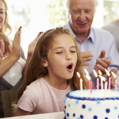 blowing out candles at a birthday party for girls