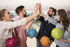group of friends enjoying a bowling birthday party together