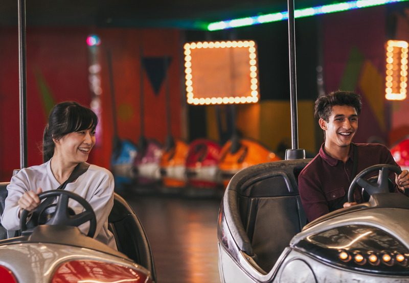 Two young friends ride bumper cars for fun things to do in Columbus, GA